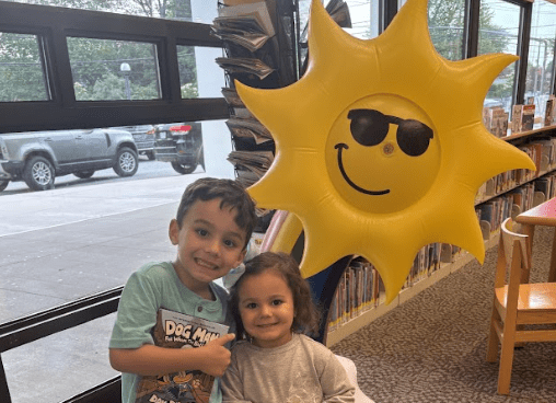 Children celebrate summer reading by taking out books from the Syosset library.