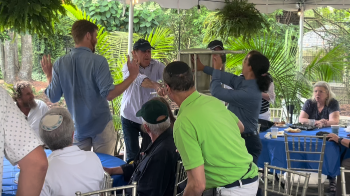 A man attacks two climate activists with a chair during Lee Zeldin's speech at The Hamptons Synagogue.