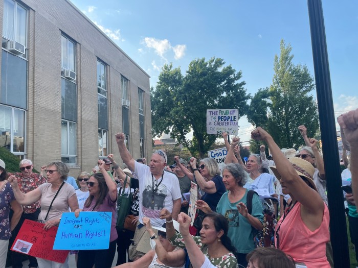 Protestors put a fist in the air while chanting, expressing their anger.
