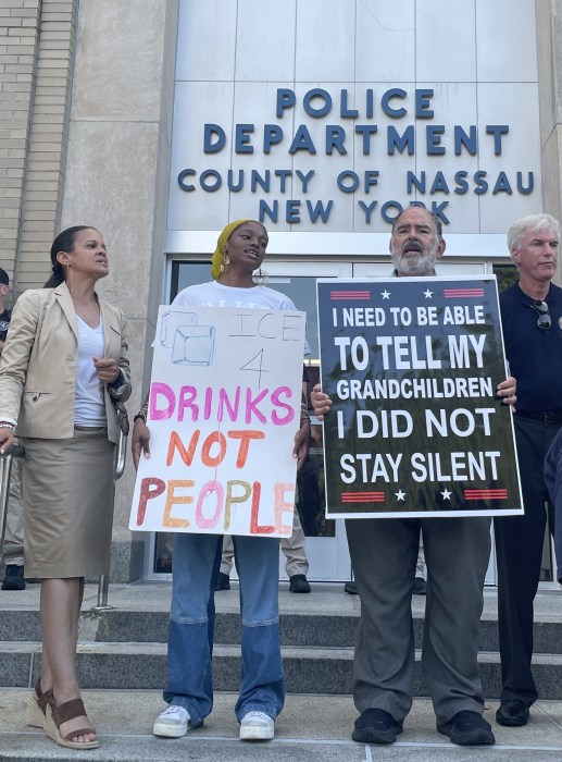 Joylette Williams (L.) joined by protestors on the steps of the Nassau County Police Department.