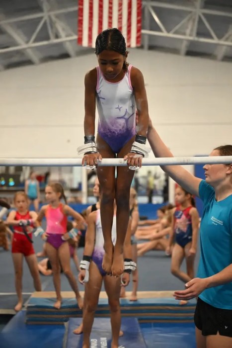 Caila Smith practices her skills on the bar prior to her competing in the Junior Olympics.