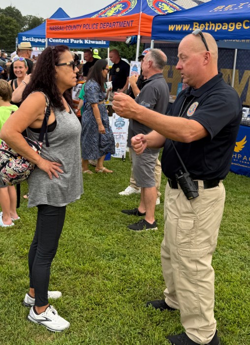 A local Nassau County police officer speaking with a resident during the event.