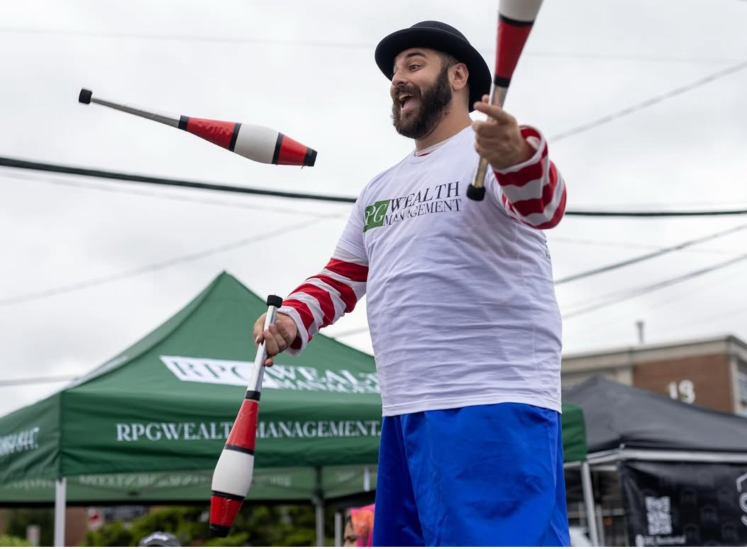 Street performers, including a man juggling on stilts, will return to the Syosset Street Fair next month.