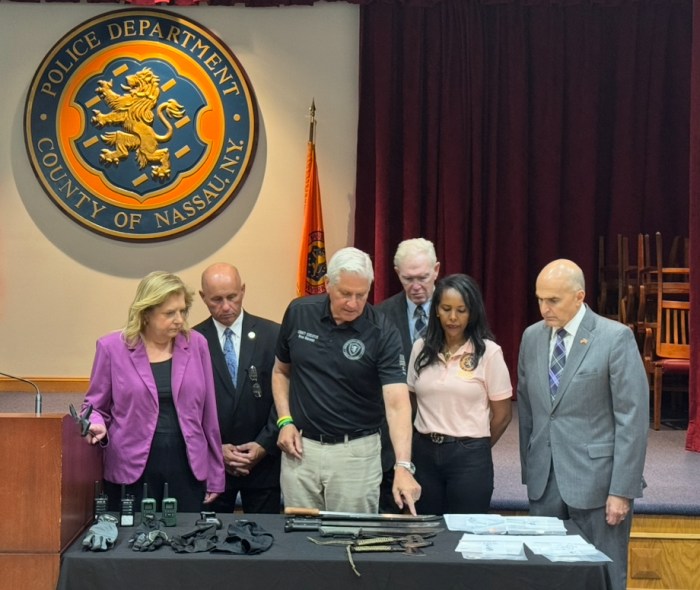 Nassau County Executive Bruce Blakeman (C.) showcases weapons allegedly used in recent gang activity.