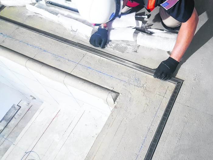 An Infinity Drain custom pool drain being installed.