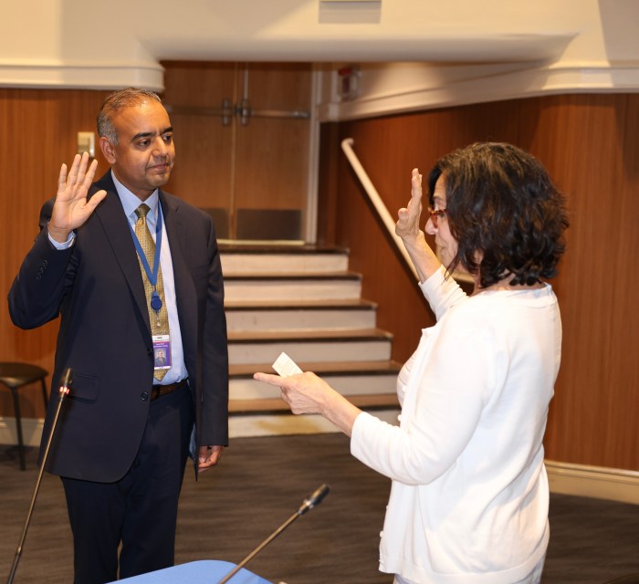 Port Washington's new superintendent, Gaurav Passi (left), was sworn into office by District Clerk Ruth Smith (right).