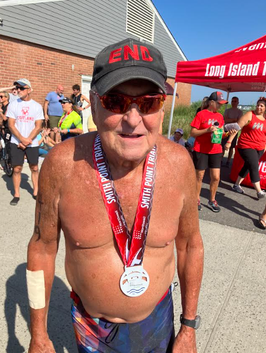 Alan End with his medal at the finish line of the Smith Point Triathlon.