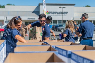 Event volunteers help organize donated items, including non-perishables and homeware.