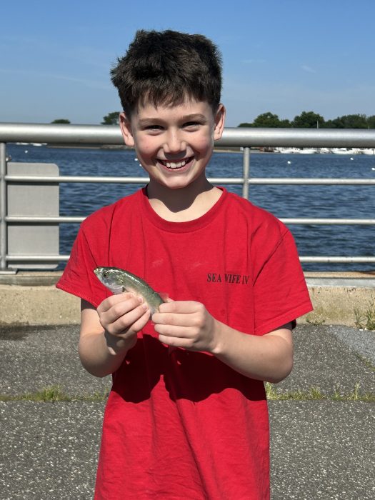 A young fisherman holds his catch at the Snapper Derby