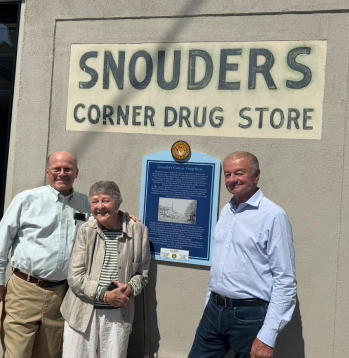 Town Historian and direct relative of Theodore Roosevelt John Hammond, daughter of Snouder's pharmacist Judith Colwell and resident Mike Rich celebrate the plaque's unveiling.