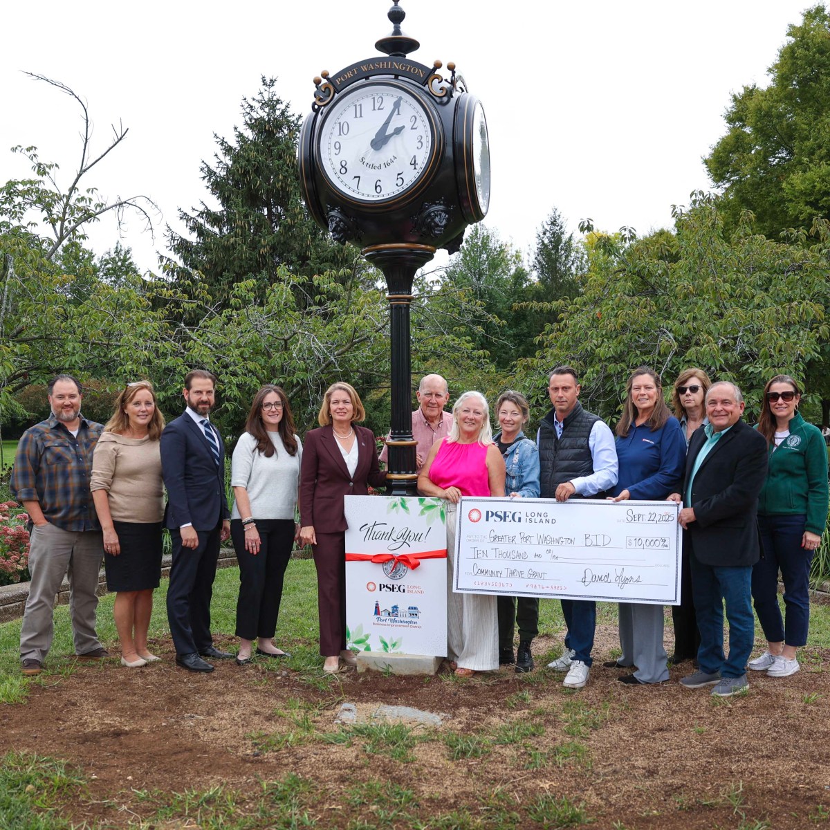 North Hempstead Supervisor Jennifer DeSena and Holly Byrne of the Greater Port Washington BID join members of PSEG Long Island and local officials to celebrate a new street clock at Blumenfeld Family Park in Port Washington.