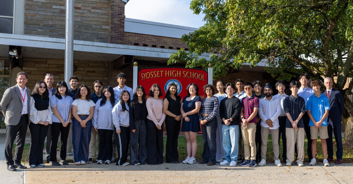 Syosset High School principal John Durante (Far L.) and Syosset Superintendent Thomas Rogers (Far R.) stand with the 24 seniors who were named National Merit semifinalists.