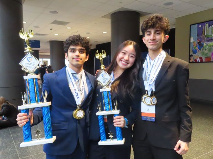 (L.) to (R.) Dev Lakhani, Kaylin Kim and Dylan Rateshwar at New York State Future Business Leaders of America competition, celebrating their victories with trophies and medals.