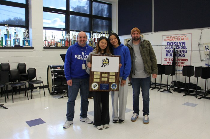 Roslyn High School principal Dave Lazarus and Band Director Frank Mauriello with two students holding their second place plaque.