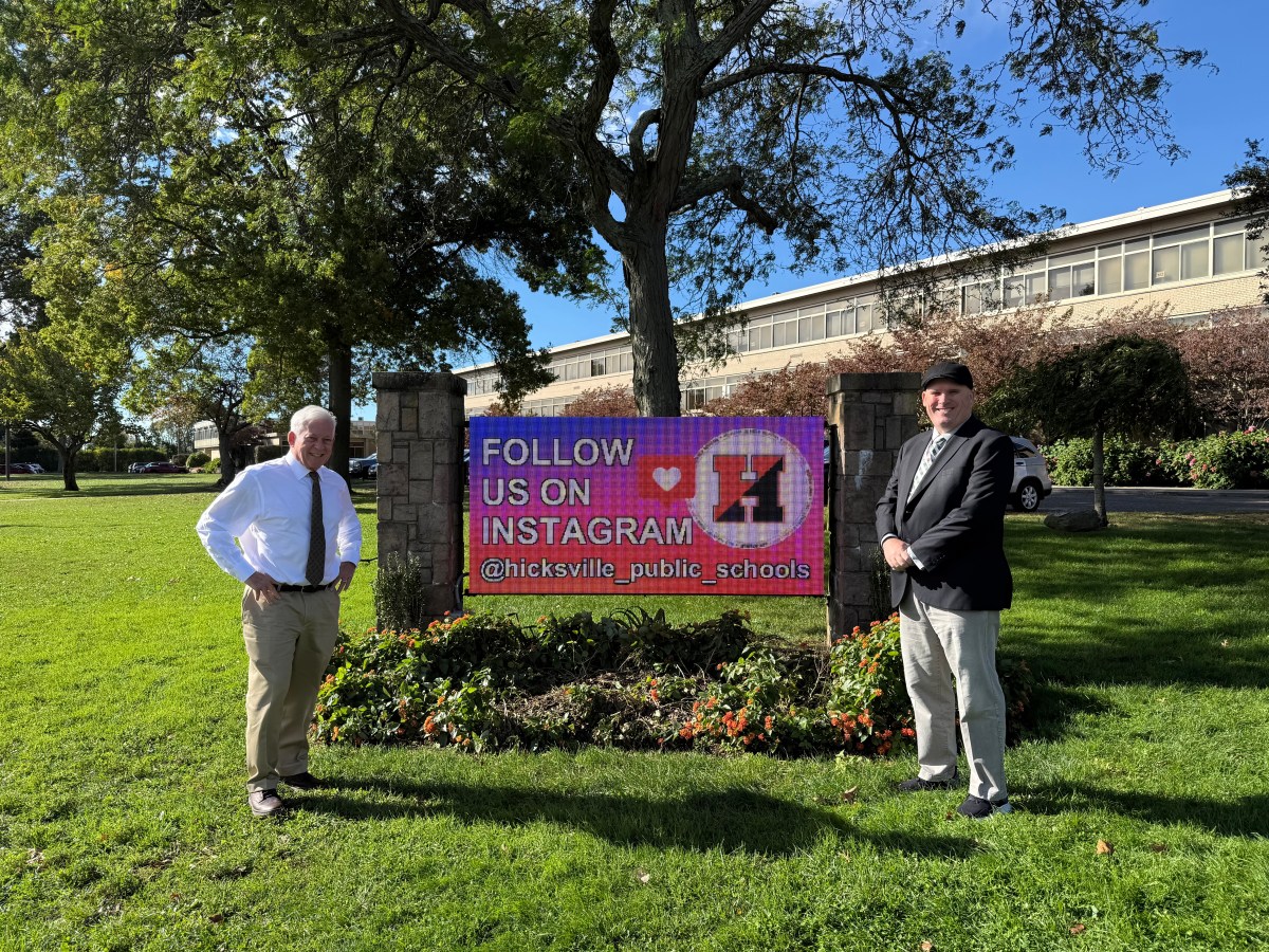 State Assembly Member Charles Lavine and Hicksville Public Schools Superintendent Theodore Fulton at the new digital sign in front of Hicksville High School,