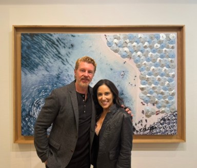 Dennis Leon (L.) and Natalia Good (R.) stand in front of Leon's paintings at the grand opening of Leon+Good Gallery in Locust Valley.