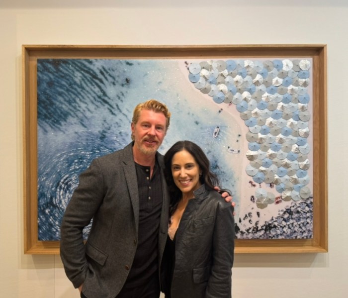 Dennis Leon (L.) and Natalia Good (R.) stand in front of Leon's paintings at the grand opening of Leon+Good Gallery in Locust Valley.