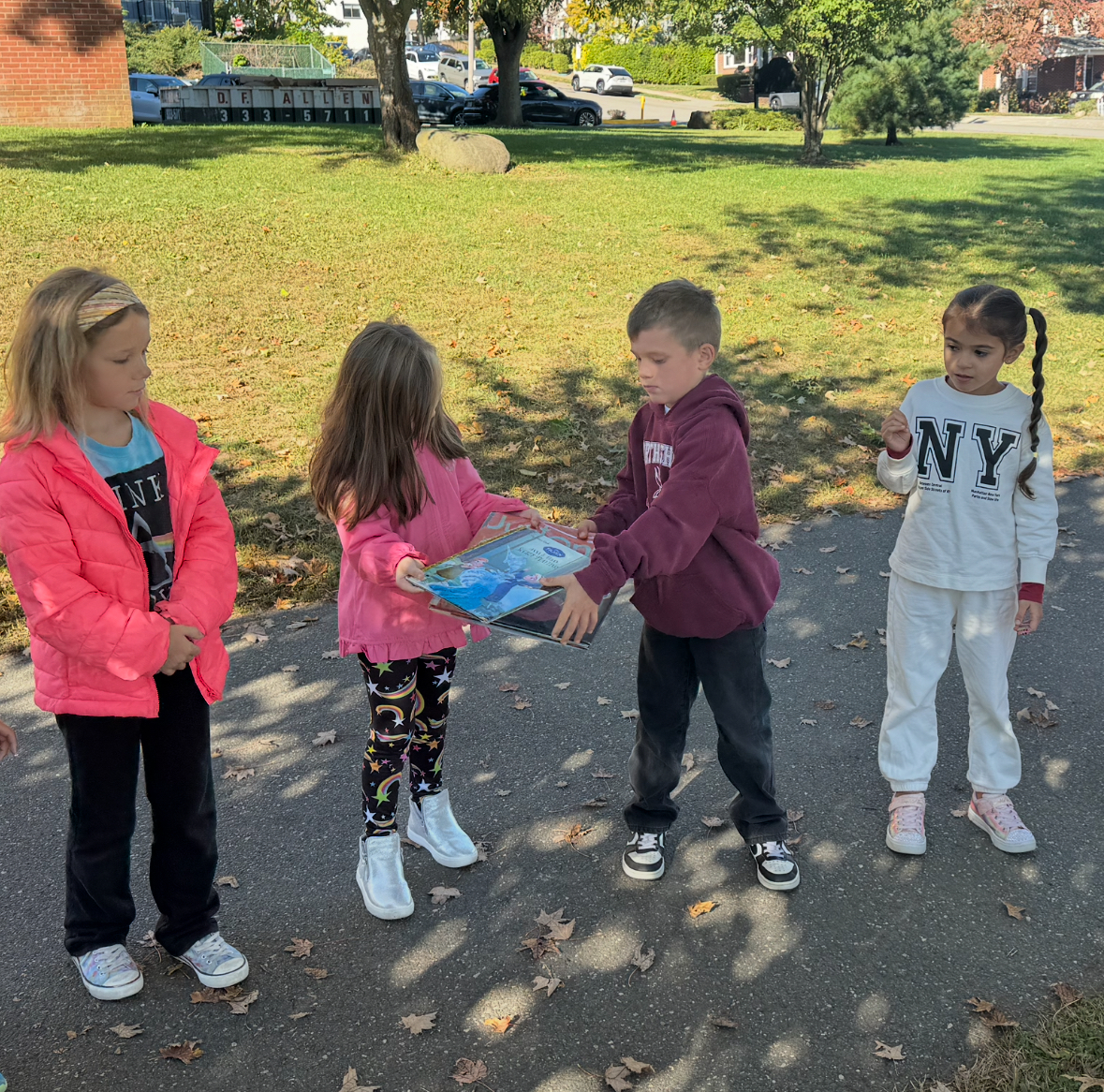 Pre-schoolers help in the book brigade by passing books to one another.