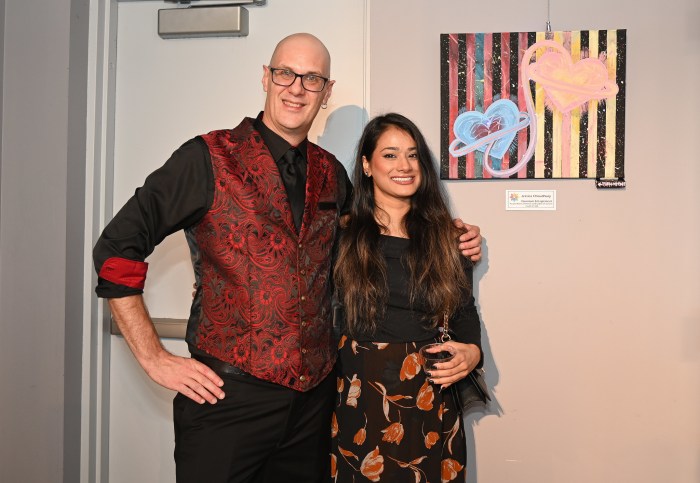 Jay Stuart and Jessica with her art work Quantum Entanglement -Acrylic Matte and Neon, LED Lights on Canvas.