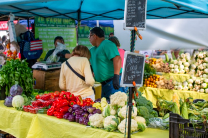 Vendors selling a variety of produce at the Syosset Farmers Market.
