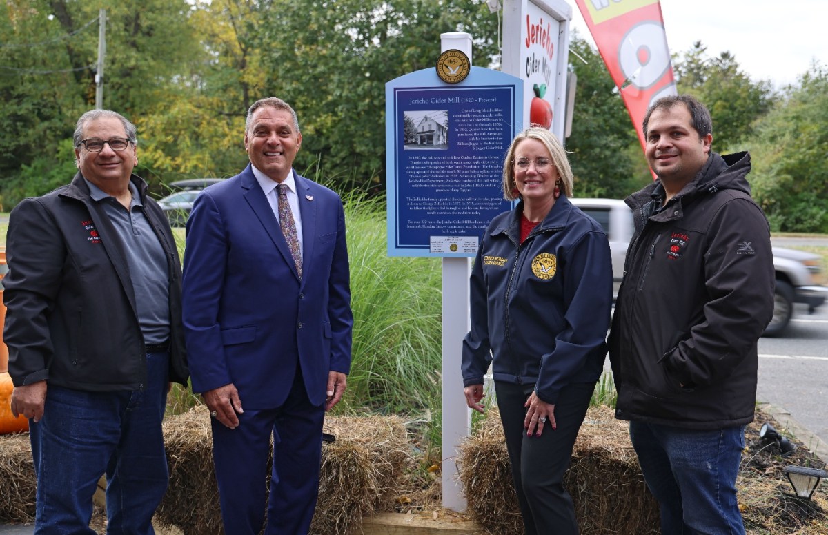 Oyster Bay Town Supervisor Joseph Saladino (second from L.) and Council Member Laura Maier unveil a historical sign commemorating more than 200 years of business at the Jericho Cider Mill, with owners Ted (L) and Kerry (R) Ketsoglou.