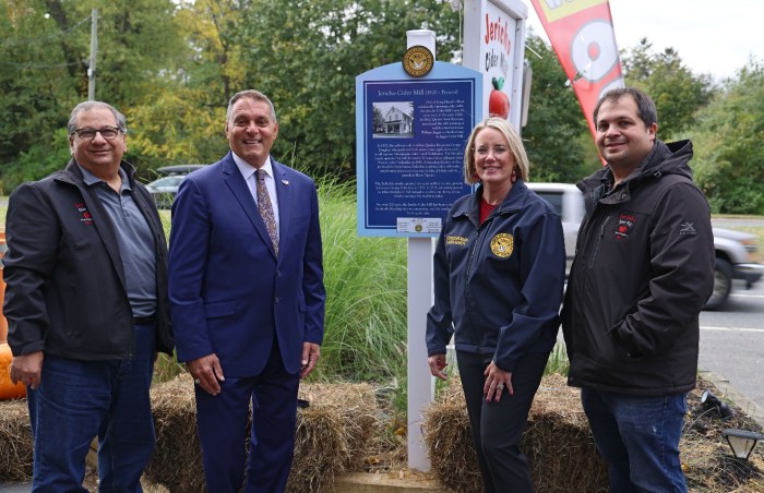 Oyster Bay Town Supervisor Joseph Saladino (second from L.) and Council Member Laura Maier unveil a historical sign commemorating more than 200 years of business at the Jericho Cider Mill, with owners Ted (L) and Kerry (R) Ketsoglou.