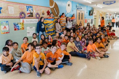 Students from all three teachers’ classes posed for a picture with their teachers taped to the wall behind them.