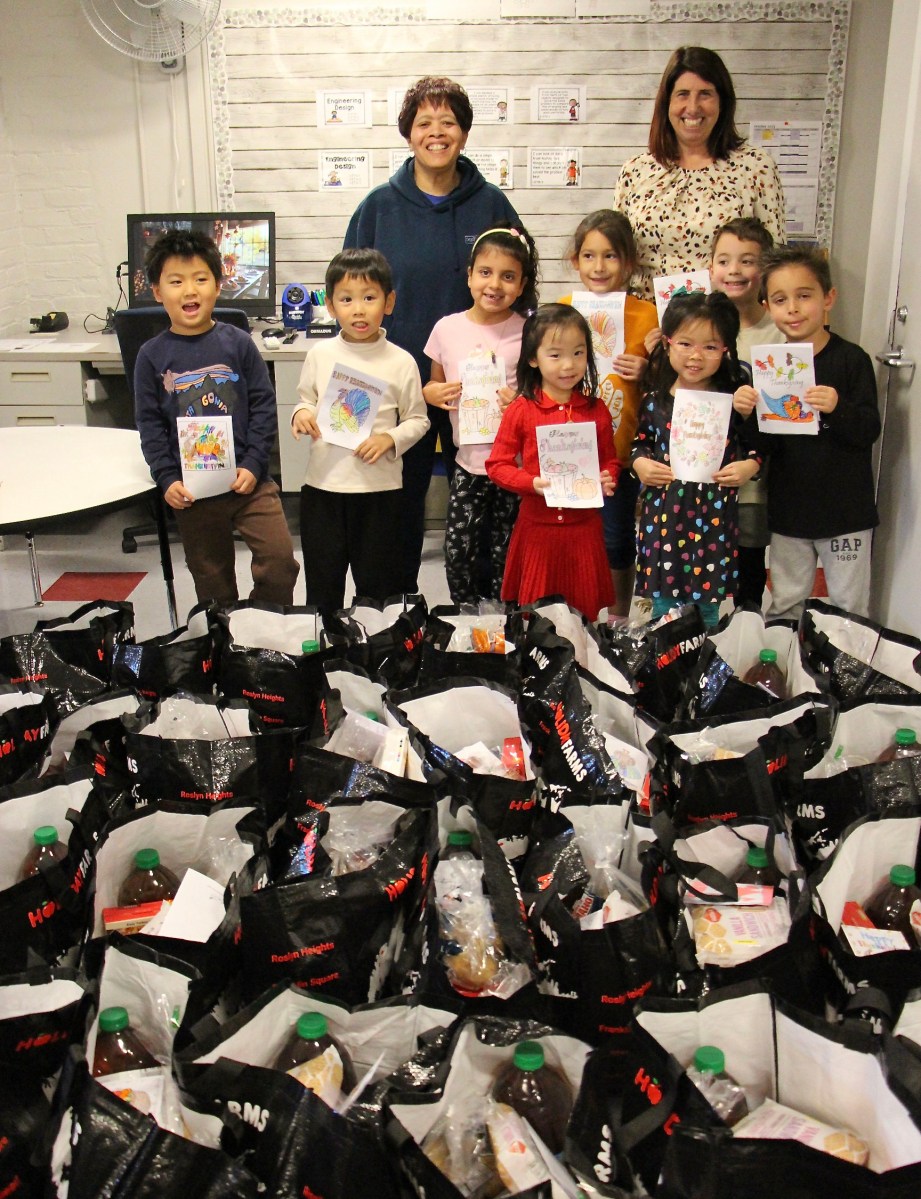 District Social Worker Tanya Fernandez and principal Mary Wood with Heights students preparing Thanksgiving meal bags.