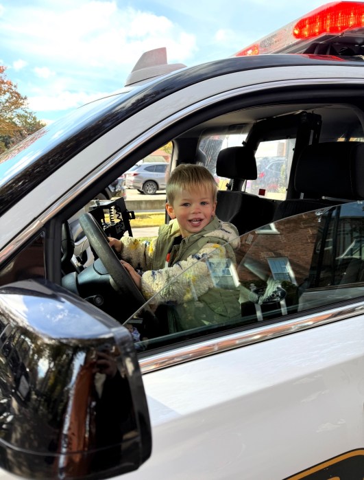 Joseph Botka, an attendee, posed in the front seat of a police vehicle.
