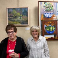 Artists Gloria Glick and Jackie Becker posed in front of their paintings, are on display at Great Neck Plaza's Village Hall.
