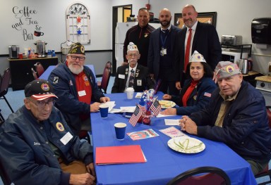 Lockhart Elementary School Principal Michael DeLuca (standing R) and Curriculum Associate for Social Studies Jason Gelardi (standing C.), greeted veterans from local organizations during a breakfast prior to the school’s annual Veterans Day ceremony.