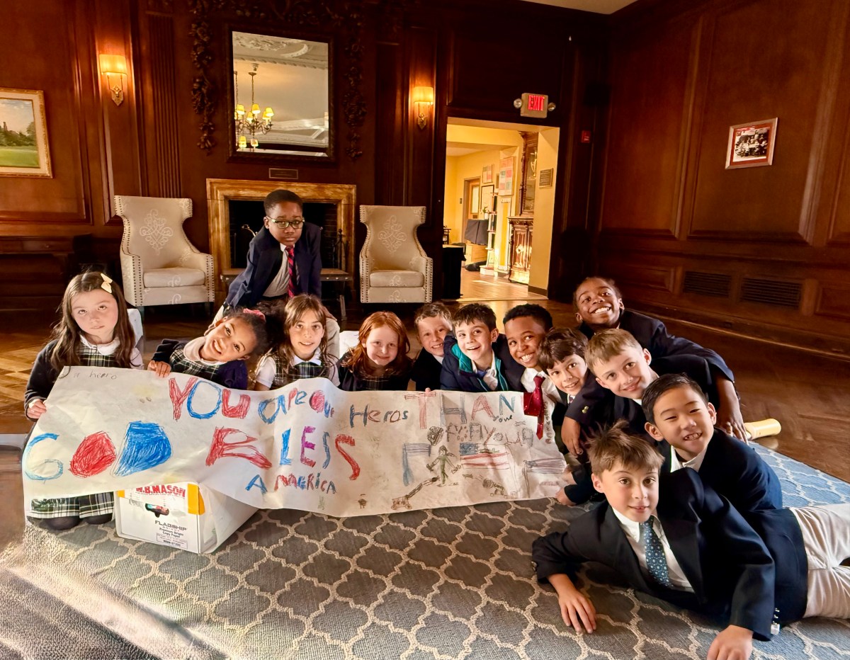 Buckley Country Day School third graders pose for a photo with the banner they created to send with the Halloween candy to U.S. Army Reserve troops in Saugerties, N.Y.