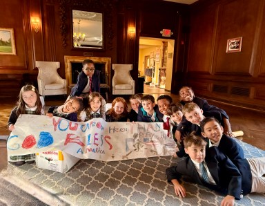 Buckley Country Day School third graders pose for a photo with the banner they created to send with the Halloween candy to U.S. Army Reserve troops in Saugerties, N.Y.
