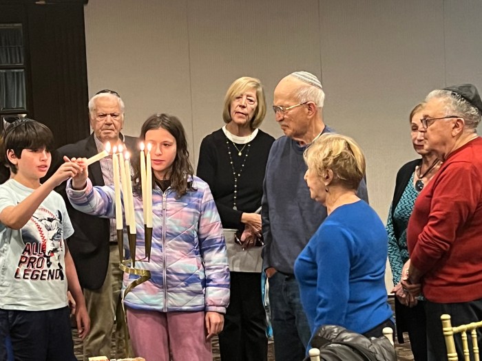 Shelter Rock Jewish Center’s “Second Generation” survivors light candles in memory ofHolocaust victims. The two children represent younger generations who must pass on the story.