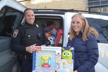 Det. Anthony Guzzello was happy to accept a carload of toys from Nassau County Legislator Delia DeRiggi-Whitton for Make a Child Smile.