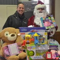 Port Washington Police Detective Anthony Guzzello with Santa and some of the toys donated by generous local residents and businesses.