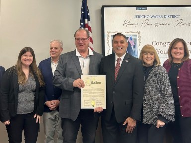 Oyster Bay Town Supervisor Joseph Saladino (third from R.) honored Jericho Water District Commissioner James Asmus (third from L.) upon his retirement.