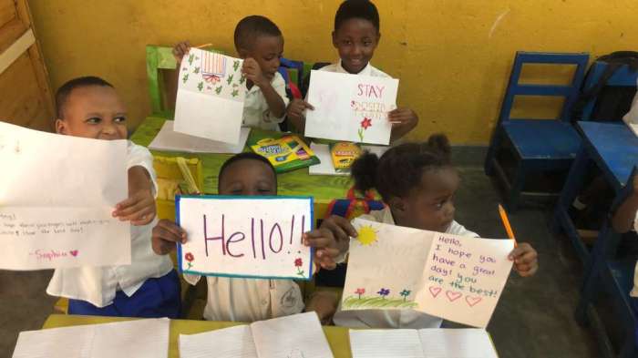 Rwandan children show off the cards they received from Herricks students.