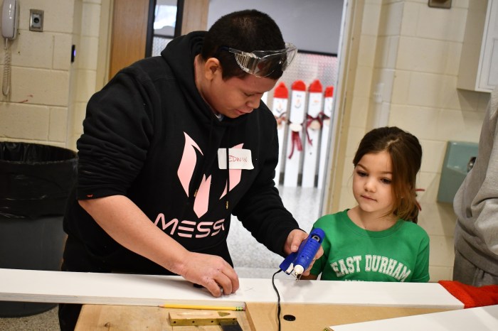 Students working together to measure snowman heights.