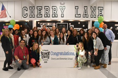 Cherry Lane teachers, Principal Moriarty and Superintendent Ted Cannone held a congratulatory banner for Cherry Lane’s super stretch accomplishments.