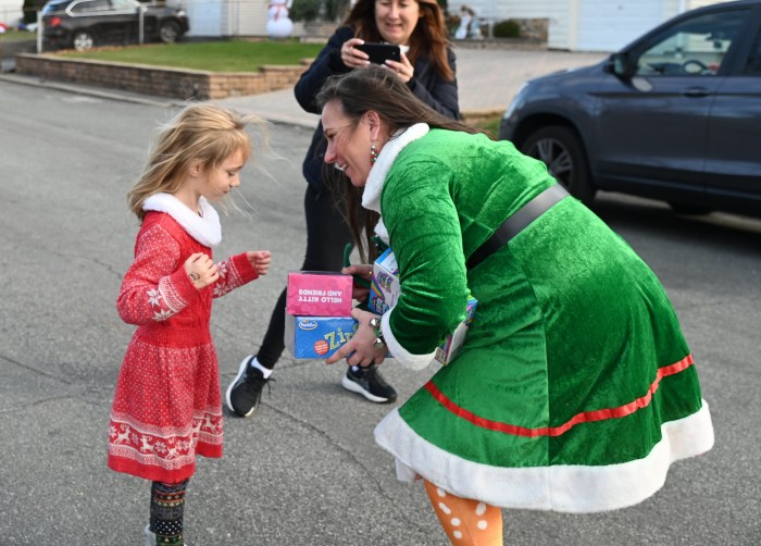 Image 11 A Reinder Rebels elf delivering a toy to a young girl