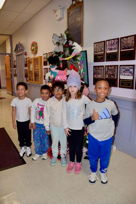John Lewis Childs School students are pictured with the Mitten Tree in the school’s main hallway.
