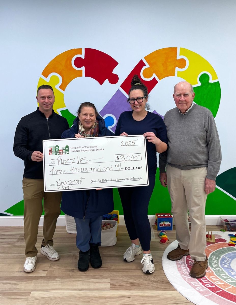 Sofia Kokkoris-Christakis, owner of Puzzles, accepts grant awards for new tenant and new sign from Port Washington BID Board members, Michael Tretola, Council Member Mariann Dalimonte, and Bill Haagenson.