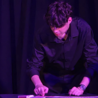 Jacob Goetz, a Syosset magician, performs card tricks on stage for audiences