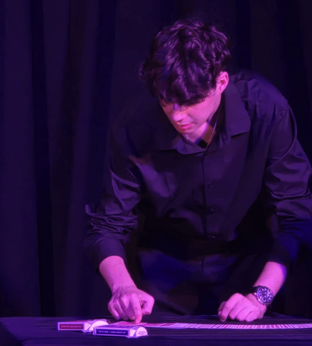 Jacob Goetz, a Syosset magician, performs card tricks on stage for audiences