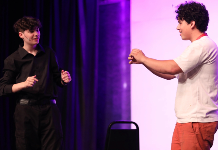 Alongside a volunteer from the audience, Goetz entertains at a local event.