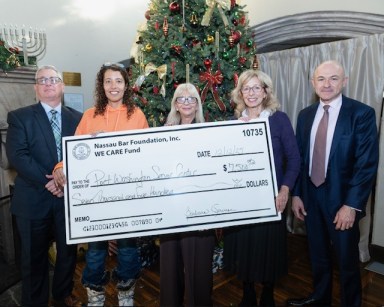 Members of the WE CARE Fund and Port Washington Adult Activities Center with a grant for the center.