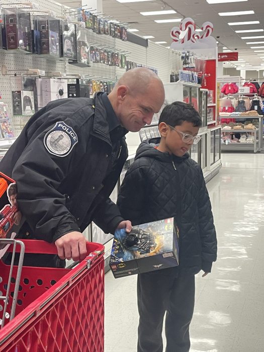 A Sands Point Police Officer helping a child pick out a toy.