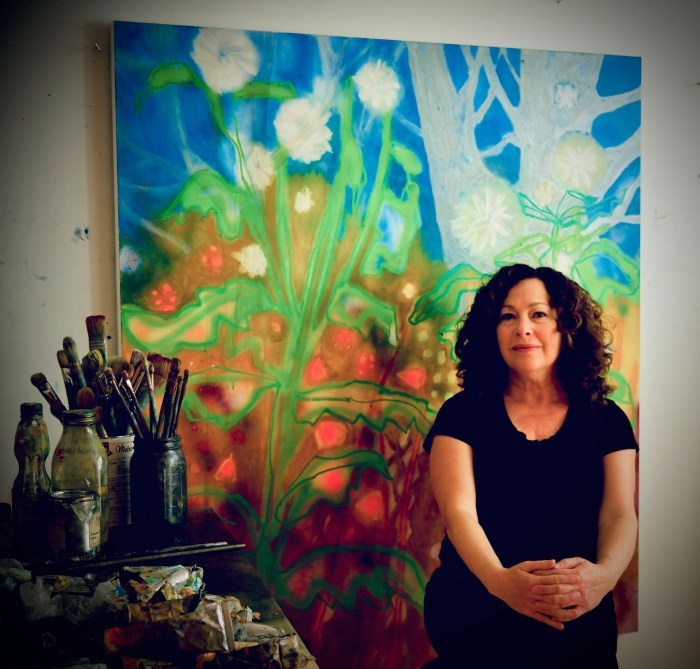 Port Washington based artist Rachelle Kreiger with her painting from her exhibit "Day Dreams and Night Visions" on show at the Port Washington Public Library.
