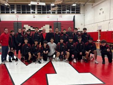 Mineola wrestling coach Dan Guido celebrates with student-athletes following historic 400th win as head coach